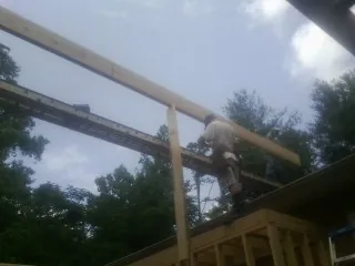 Carpenter setting a ridge beam over a new addition frame — Ice Dam Removal by Roofing Brothers in Cornwall