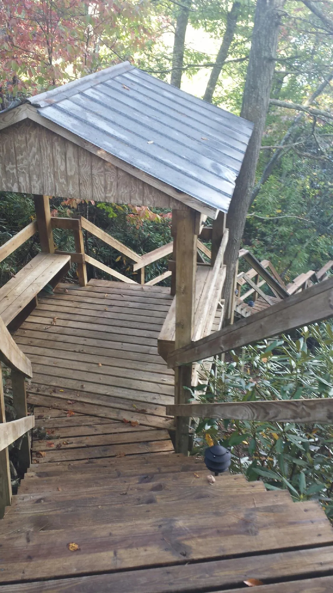 Metal roofed shelter over wooden steps on a wooded walkway — Skylight Repair & Installation work by our crew in Cornwall