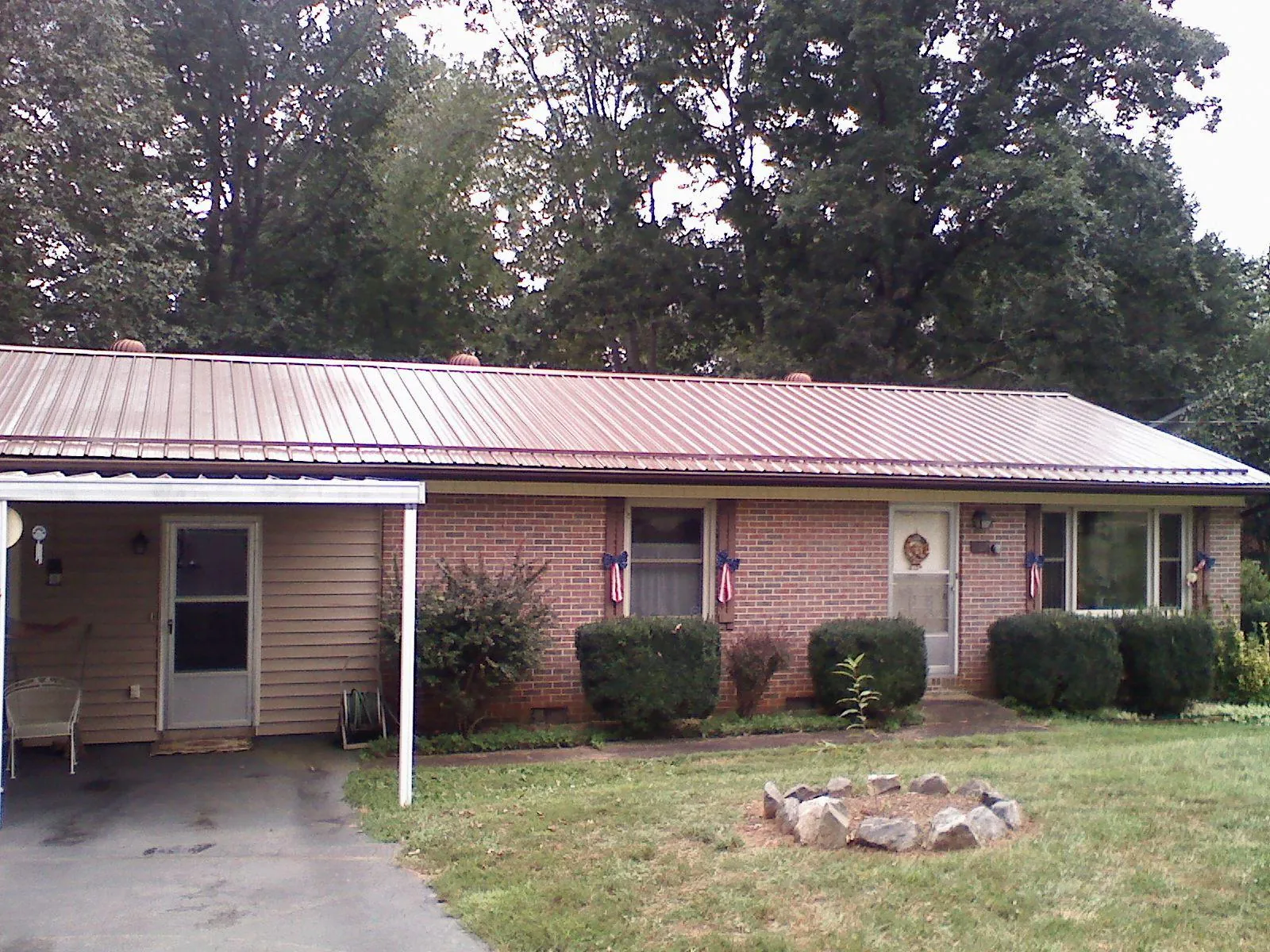 Bronze metal roof and carport on a brick ranch home — Roof Repair work by our crew in Cornwall